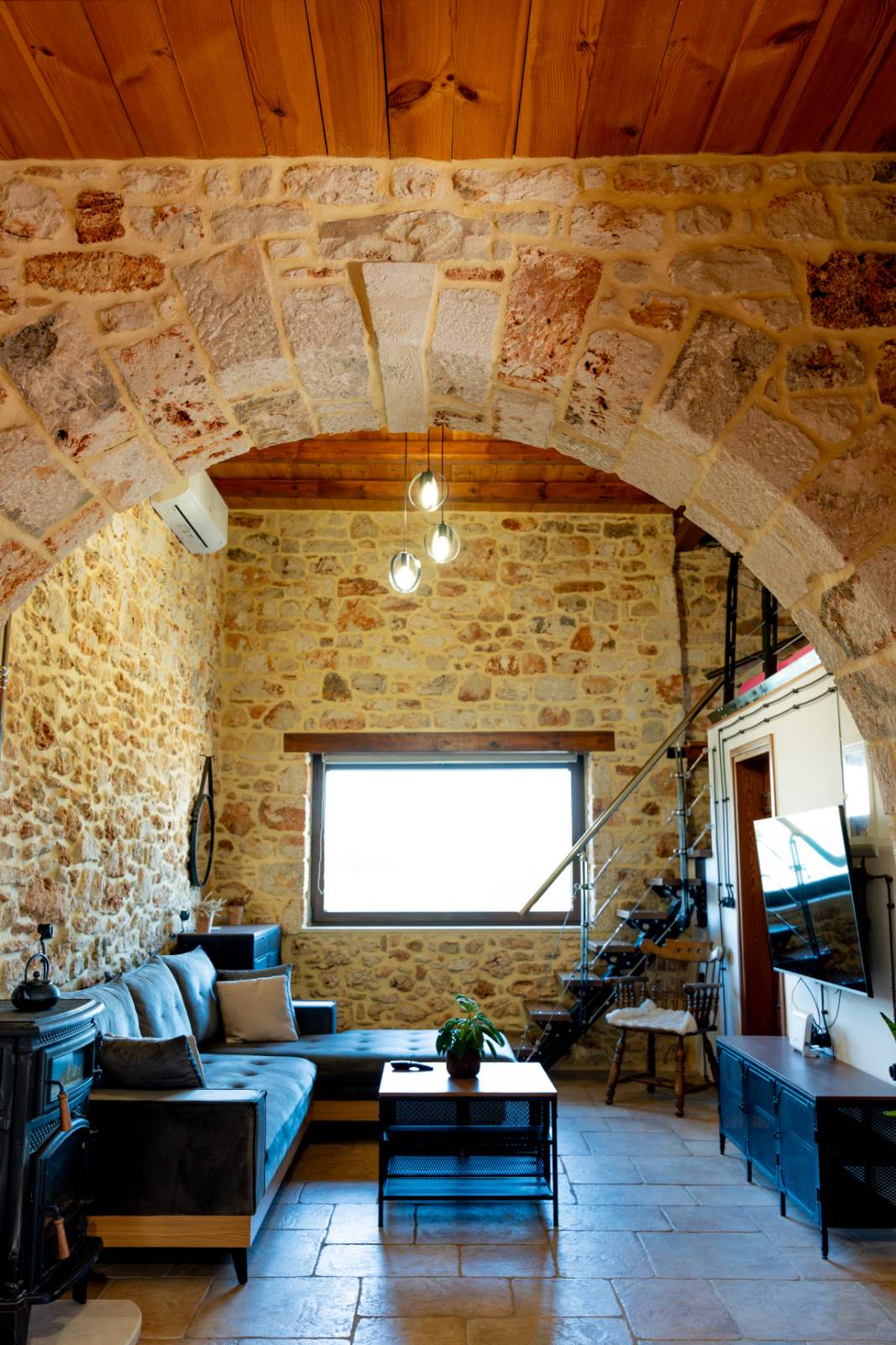 Living room with traditional stone arch and spiral staircase