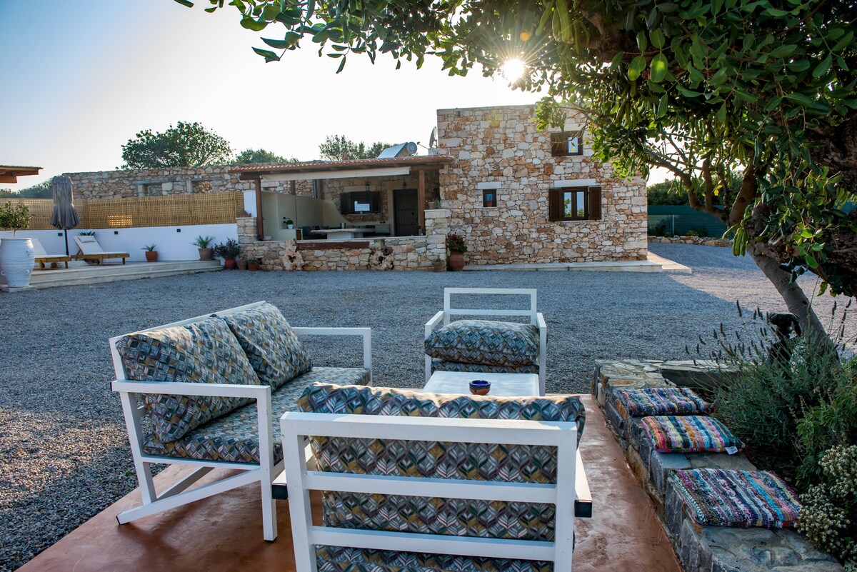 Garden lounge area with villa at golden hour